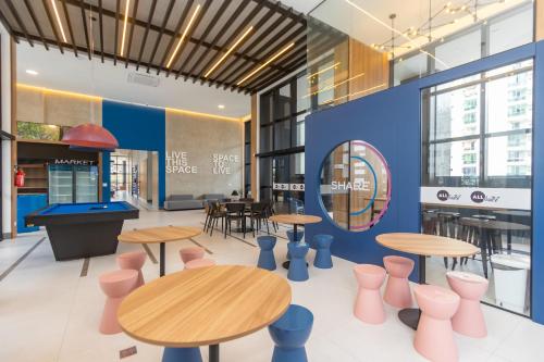 a restaurant with tables and chairs and a pool table at All Batel - Suyts in Curitiba