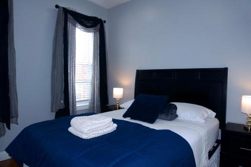 a bedroom with a bed with two towels on it at New York private room 31 in West New York