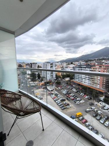 a balcony with a chair and a view of a parking lot at ONE Luxury Suite Super King Bed & Volcano View in Quito