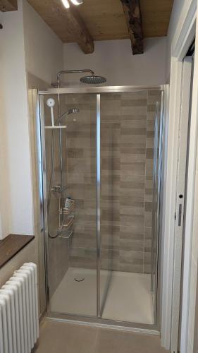 a shower with a glass door in a bathroom at Locanda alla Nave in Pianzano
