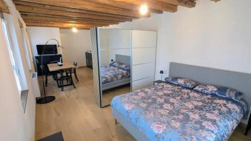 a bedroom with a bed and a desk and a table at Locanda alla Nave in Pianzano