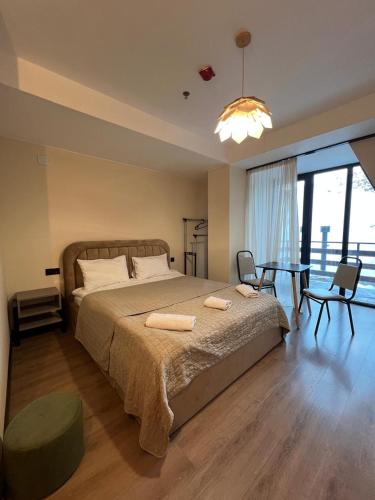 a bedroom with a large bed and a table with chairs at Nirvana Stays Gudauri in Gudauri