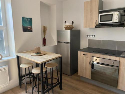 a kitchen with a small table and a refrigerator at Charmant T2 cosy à Mazamet in Mazamet