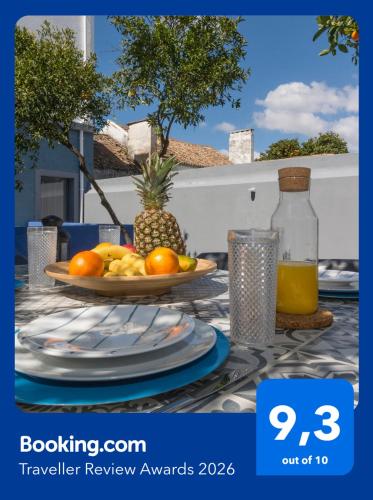 a table with a plate of fruit and a pineapple at OrangeTreeHouses in Montijo