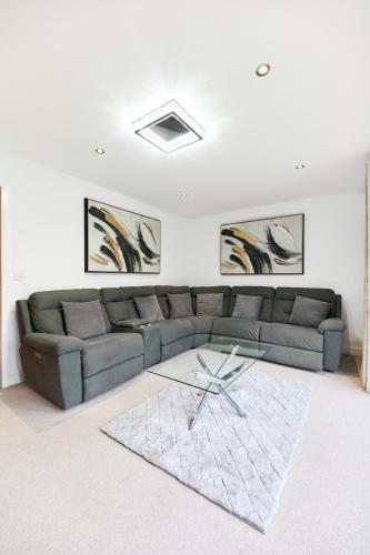 a living room with a couch and a glass table at Haven - Spacious Luxury Home perfect for families, couples and contractors! 5mins to Xscape and Junction 32! in Castleford