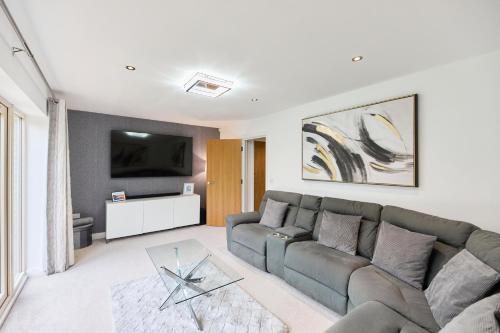 a living room with a couch and a tv at Haven - Spacious Luxury Home perfect for families, couples and contractors! 5mins to Xscape and Junction 32! in Castleford