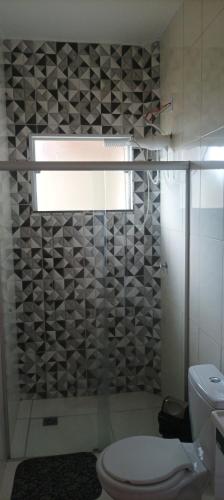 a bathroom with a toilet and a glass shower at Hospedagem mobiliada in Tupã