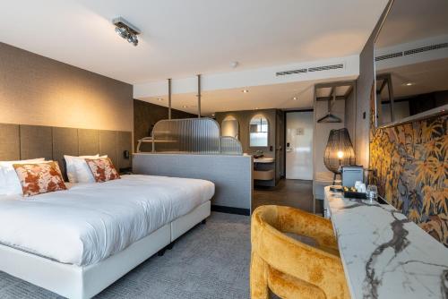 a hotel room with a large bed and a couch at Van der Valk Hotel Assen in Assen