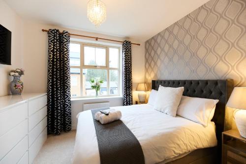 a bedroom with a large bed and a window at Haven - Spacious Luxury Home perfect for families, couples and contractors! 5mins to Xscape and Junction 32! in Castleford