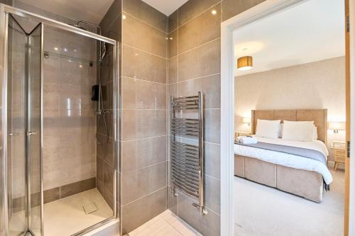 a master bedroom with a shower and a bed at Haven - Spacious Luxury Home perfect for families, couples and contractors! 5mins to Xscape and Junction 32! in Castleford