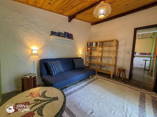 a living room with a blue couch and a table at Chalés Canoa in Ilhabela