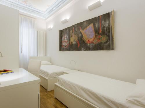 フィレンツェにあるApartments Florence - Duomo Artのベッドルーム1室(ベッド2台付)が備わります。壁には絵画が飾られています。
