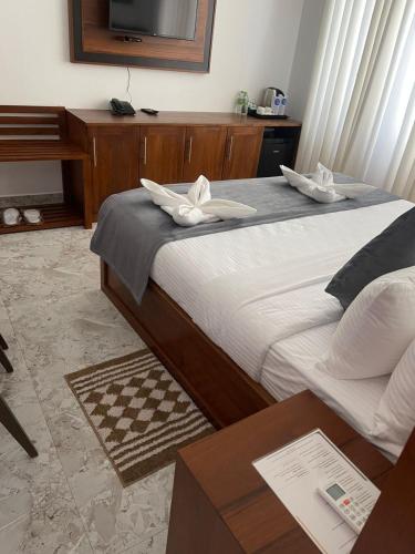 a bedroom with two beds and a tv and a table at inner pease in Nikawatawana