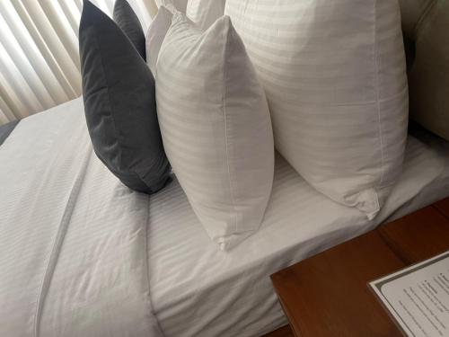 a white bed with two pillows on top of it at inner pease in Nikawatawana