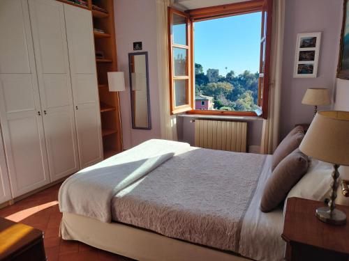 a bedroom with a bed and a large window at L'Alcova tra gli ulivi in Zoagli
