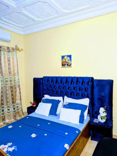 a blue bed with a blue headboard in a room at Appartement Meublé 3 Chambres in Douala