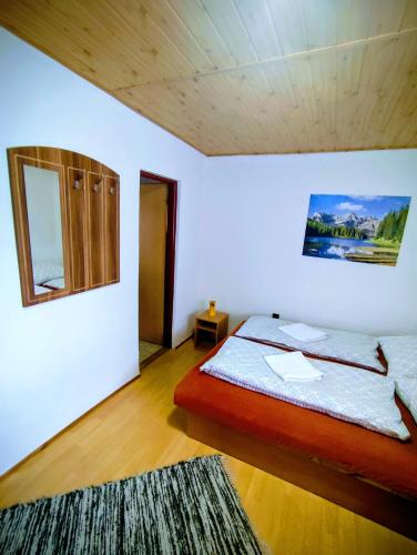 a bedroom with a bed and a mirror on the wall at Dovolenkový dom Zuberec in Zuberec