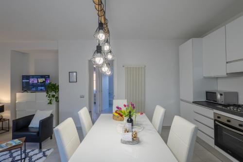 a kitchen and dining room with a white table and chairs at LAKE COMO BORGO VIGNOLA - Cozy Apartment in a Charming Village in Cremia