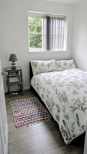 a bedroom with a bed and a table and a window at Leeds City Junction in Beeston Hill