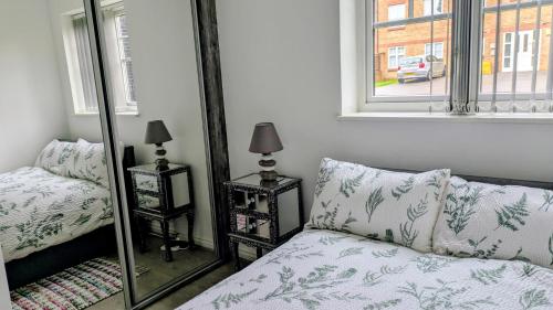 a bedroom with a bed and a mirror next to a window at Leeds City Junction in Beeston Hill