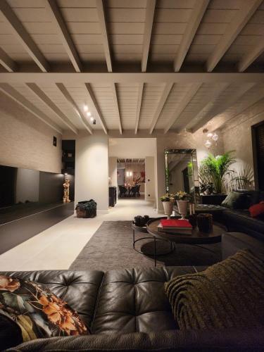 a large living room with a leather couch and tables at Obobonne in Geraardsbergen