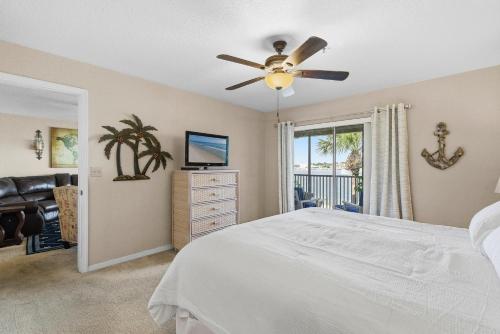 a bedroom with a bed and a ceiling fan at Bouchelle Island 203 in New Smyrna Beach