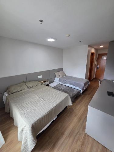 a bedroom with two beds in a room at Flat 709 - Hotel Comfort Taguatinga in Brasília