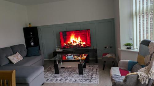 a living room with a fire in the fireplace at Leeds City Junction in Beeston Hill