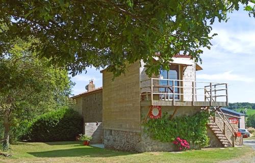 La Cabane في Chambretaud: منزل به شرفة على جانبه