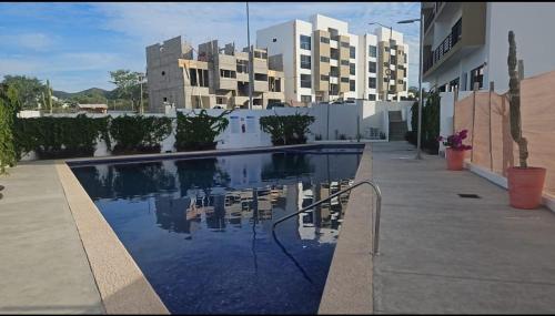 a swimming pool in front of a large building at chema in Cabo San Lucas