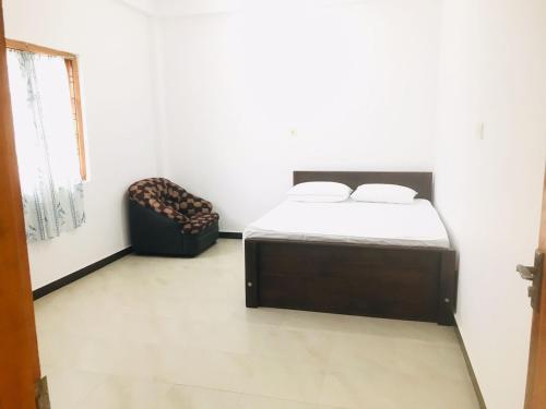 a bedroom with a bed and a chair in it at Blue Deer Villa in Trincomalee