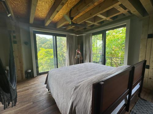 a woman standing in a bedroom with a large bed at KINEKI La Punta - Casa Karen in Brisas de Zicatela