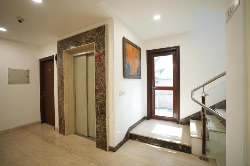 a hallway with stairs and a door and a window at EMBLEM Hotel - Arjun Marg, Golf Course Road, Gurgaon in Gurgaon