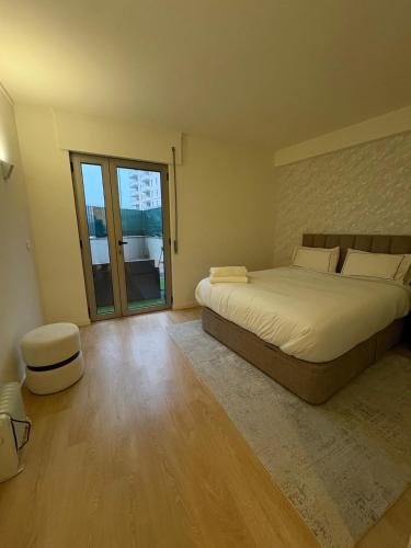 a bedroom with a large bed and a large window at 2BR Retreat in Lumiar near airport w Patio in Lisbon