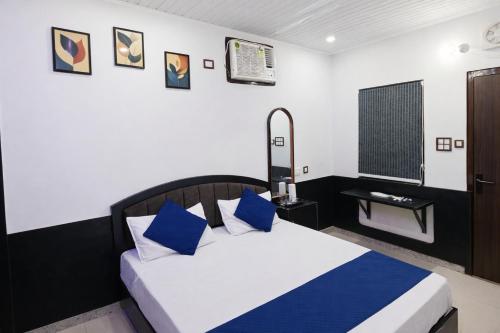 a bedroom with a bed with blue pillows at Hotel In Varanasi in Varanasi