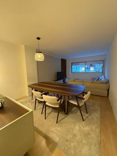 a dining room with a table and chairs and a couch at 2BR Retreat in Lumiar near airport w Patio in Lisbon