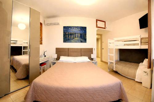 a bedroom with a bed and two bunk beds at Oasi Brembate Bed and Breakfast in Brembate