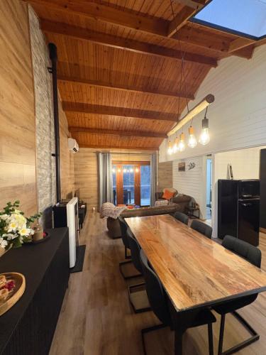 a living room with a wooden table and a couch at Chalet La Vallée La Boverie in Rendeux