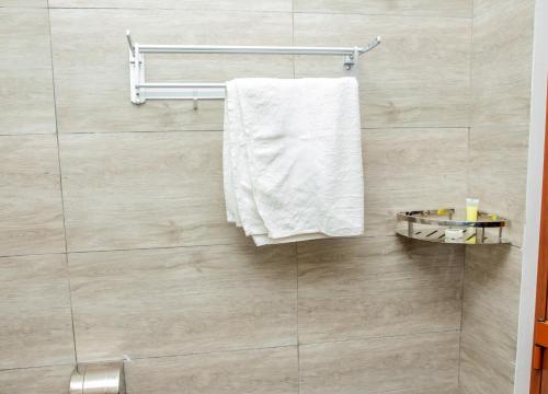 a bathroom with a white towel hanging on a wall at Spring Hills Group in Dodoma