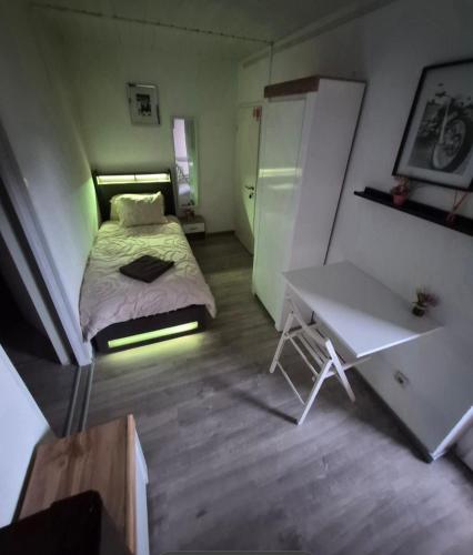 a small bedroom with a bed and a desk at Pension Mediterrano - Monteurzimmer in Bedburg
