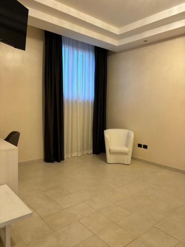 a room with a white chair and a window at Hotel Donna Crescenza in Locorotondo