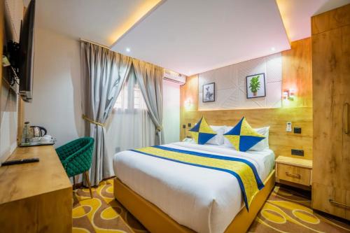 a hotel room with a bed and a desk at Afro Park Hotel in Kampala