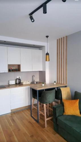 a kitchen with a table and a green couch at Emerald Mamba - Titova Vila in Zlatibor