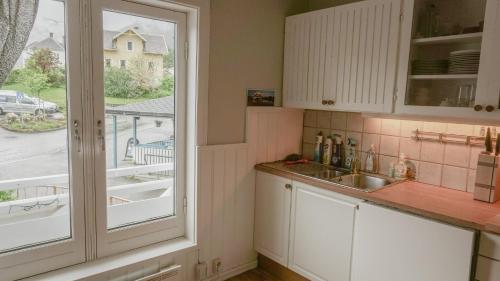 a kitchen with a large window and a sink at Svingen Apartments in Balestrand