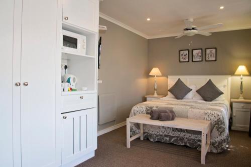 a bedroom with a bed and a table in it at Bayside Guesthouse in Port Elizabeth