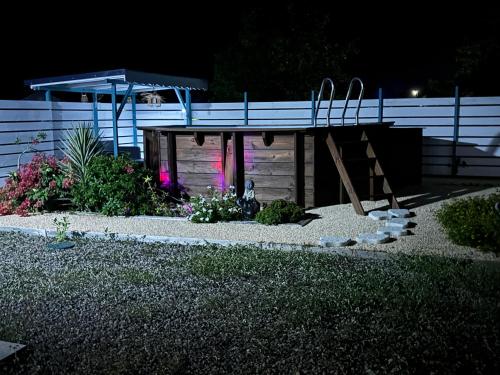 a backyard garden at night with a wooden shed at Rêve Bleu in Capesterre