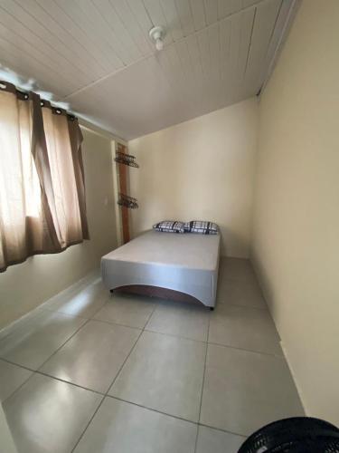 a bedroom with a bed in the corner of a room at Casa São Francisco do Sul - #2 in São Francisco do Sul