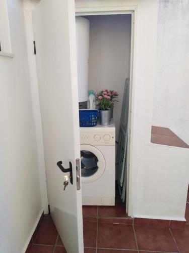 a door open to a kitchen with a washing machine at Casa BENVINDHA in Degolados