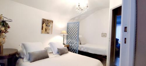 a bedroom with two beds and a chandelier at PARIS AUTHENTIC HOUSE Métro 7 Pierre et Marie Curie in Paris
