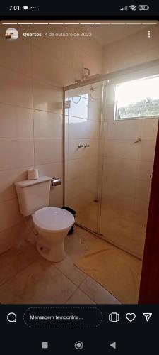 a bathroom with a toilet and a shower at Pousada DrChico in Poço Fundo